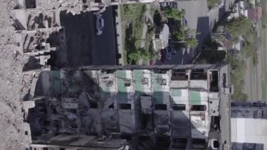 This stock vertical video shows the aftermath of the war in Ukraine - a destroyed residential building in Borodyanka, grey, flat video