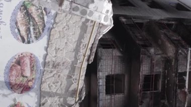 This stock vertical video shows the aftermath of the war in Ukraine - a destroyed residential building in Borodyanka, grey, flat video