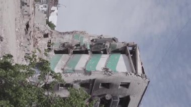 This stock vertical video shows the aftermath of the war in Ukraine - a destroyed residential building in Borodyanka, grey, flat video