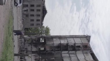 This stock vertical video shows the aftermath of the war in Ukraine - a destroyed residential building in Borodyanka, grey, flat video