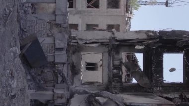 This stock vertical video shows the aftermath of the war in Ukraine - a destroyed residential building in Borodyanka, grey, flat video