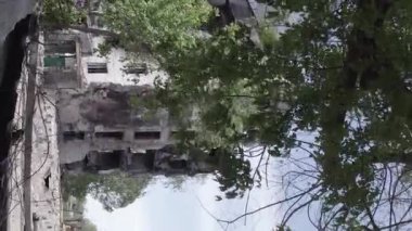 This stock vertical video shows the aftermath of the war in Ukraine - a destroyed residential building in Borodyanka, grey, flat video