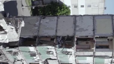 This stock vertical video shows the aftermath of the war in Ukraine - a destroyed residential building in Borodyanka, grey, flat video
