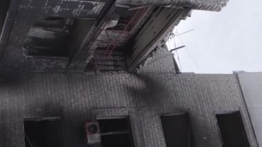 This stock vertical video shows the aftermath of the war in Ukraine - a destroyed residential building in Borodyanka, grey, flat video