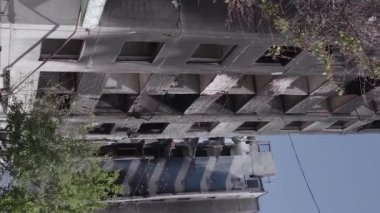 This stock vertical video shows the aftermath of the war in Ukraine - a destroyed residential building in Borodyanka, grey, flat video