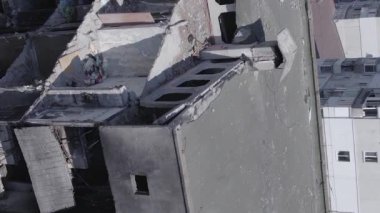 This stock vertical video shows the aftermath of the war in Ukraine - a destroyed residential building in Borodyanka, grey, flat video