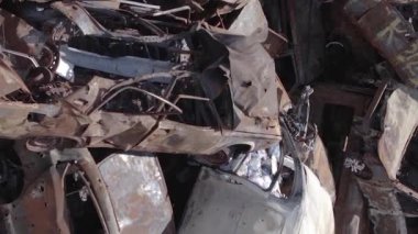 This stock vertical video shows a dump of shot and burned cars in Irpin, Bucha district , grey, flat video