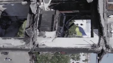 This stock vertical video shows the aftermath of the war in Ukraine - a destroyed residential building in Borodyanka, grey, flat video