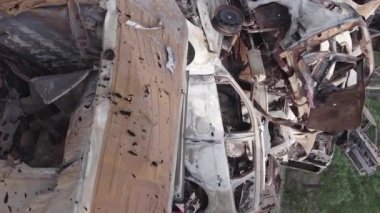 This stock vertical video shows a dump of shot and burned cars in Irpin, Bucha district , grey, flat video