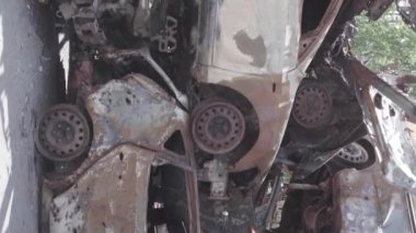 This stock vertical video shows a dump of shot and burned cars in Irpin, Bucha district , grey, flat video