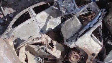 This stock vertical video shows a dump of shot and burned cars in Irpin, Bucha district , grey, flat video