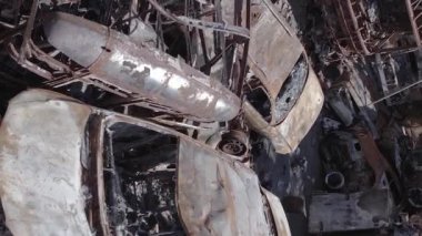This stock vertical video shows a dump of shot and burned cars in Irpin, Bucha district , grey, flat video
