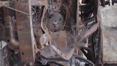 This stock vertical video shows a dump of shot and burned cars in Irpin, Bucha district , grey, flat video