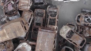 This stock vertical video shows a dump of shot and burned cars in Irpin, Bucha district , grey, flat video