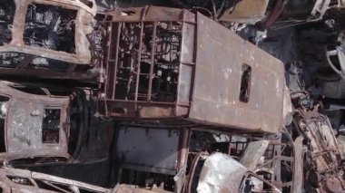 This stock vertical video shows a dump of shot and burned cars in Irpin, Bucha district , grey, flat video