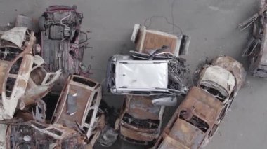 This stock vertical video shows a dump of shot and burned cars in Irpin, Bucha district , grey, flat video