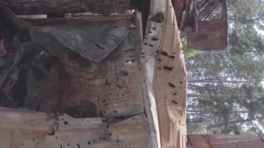 This stock vertical video shows a dump of shot and burned cars in Irpin, Bucha district , grey, flat video