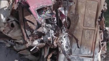 This stock vertical video shows a dump of shot and burned cars in Irpin, Bucha district , grey, flat video