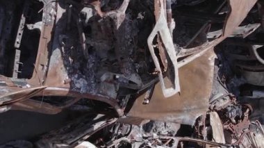 This stock vertical video shows a dump of shot and burned cars in Irpin, Bucha district , grey, flat video