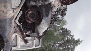 This stock vertical video shows a dump of shot and burned cars in Irpin, Bucha district , grey, flat video