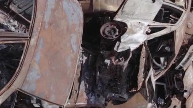 This stock vertical video shows a dump of shot and burned cars in Irpin, Bucha district , grey, flat video