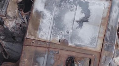 This stock vertical video shows a dump of shot and burned cars in Irpin, Bucha district , grey, flat video