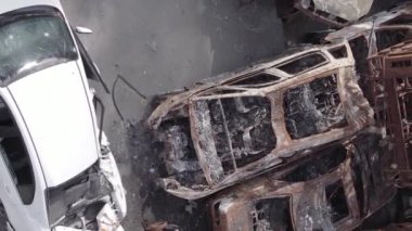 This stock vertical video shows a dump of shot and burned cars in Irpin, Bucha district , grey, flat video