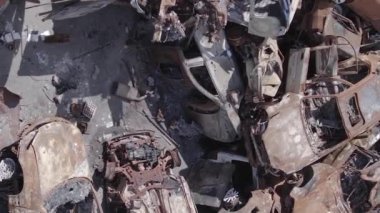 This stock vertical video shows a dump of shot and burned cars in Irpin, Bucha district , grey, flat video