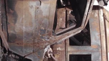 This stock vertical video shows a dump of shot and burned cars in Irpin, Bucha district , grey, flat video