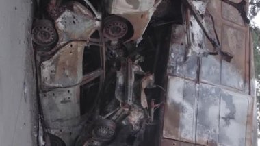 This stock vertical video shows a dump of shot and burned cars in Irpin, Bucha district , grey, flat video