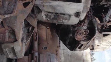 This stock vertical video shows a dump of shot and burned cars in Irpin, Bucha district , grey, flat video