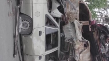This stock vertical video shows a dump of shot and burned cars in Irpin, Bucha district , grey, flat video