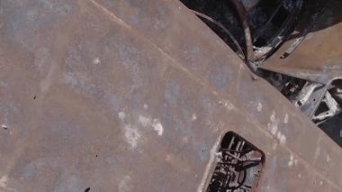 This stock vertical video shows a dump of shot and burned cars in Irpin, Bucha district , grey, flat video