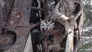 This stock vertical video shows a dump of shot and burned cars in Irpin, Bucha district , grey, flat video
