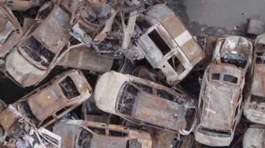 This stock vertical video shows a dump of shot and burned cars in Irpin, Bucha district , grey, flat video