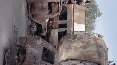 This stock vertical video shows a dump of shot and burned cars in Irpin, Bucha district , grey, flat video
