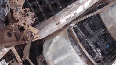 This stock vertical video shows a dump of shot and burned cars in Irpin, Bucha district , grey, flat video