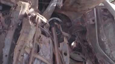 This stock vertical video shows a dump of shot and burned cars in Irpin, Bucha district , grey, flat video