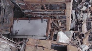 This stock vertical video shows a dump of shot and burned cars in Irpin, Bucha district , grey, flat video