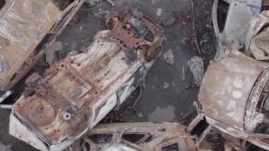 This stock vertical video shows a dump of shot and burned cars in Irpin, Bucha district , grey, flat video