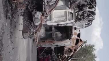 This stock vertical video shows a dump of shot and burned cars in Irpin, Bucha district , grey, flat video