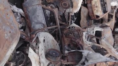 This stock vertical video shows a dump of shot and burned cars in Irpin, Bucha district , grey, flat video
