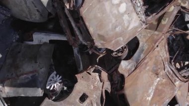 This stock vertical video shows a dump of shot and burned cars in Irpin, Bucha district , grey, flat video