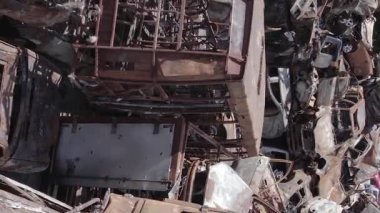 This stock vertical video shows a dump of shot and burned cars in Irpin, Bucha district , grey, flat video
