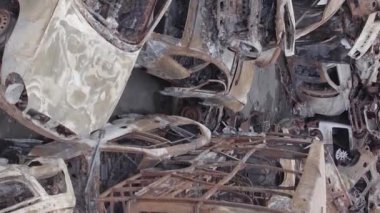 This stock vertical video shows a dump of shot and burned cars in Irpin, Bucha district , grey, flat video