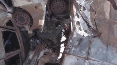 This stock vertical video shows a dump of shot and burned cars in Irpin, Bucha district , grey, flat video