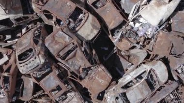 This stock vertical video shows a dump of shot and burned cars in Irpin, Bucha district , grey, flat video