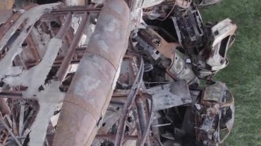 This stock vertical video shows a dump of shot and burned cars in Irpin, Bucha district , grey, flat video