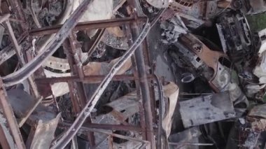 This stock vertical video shows a dump of shot and burned cars in Irpin, Bucha district , grey, flat video