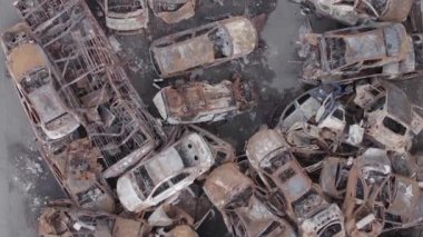 This stock vertical video shows a dump of shot and burned cars in Irpin, Bucha district , grey, flat video
